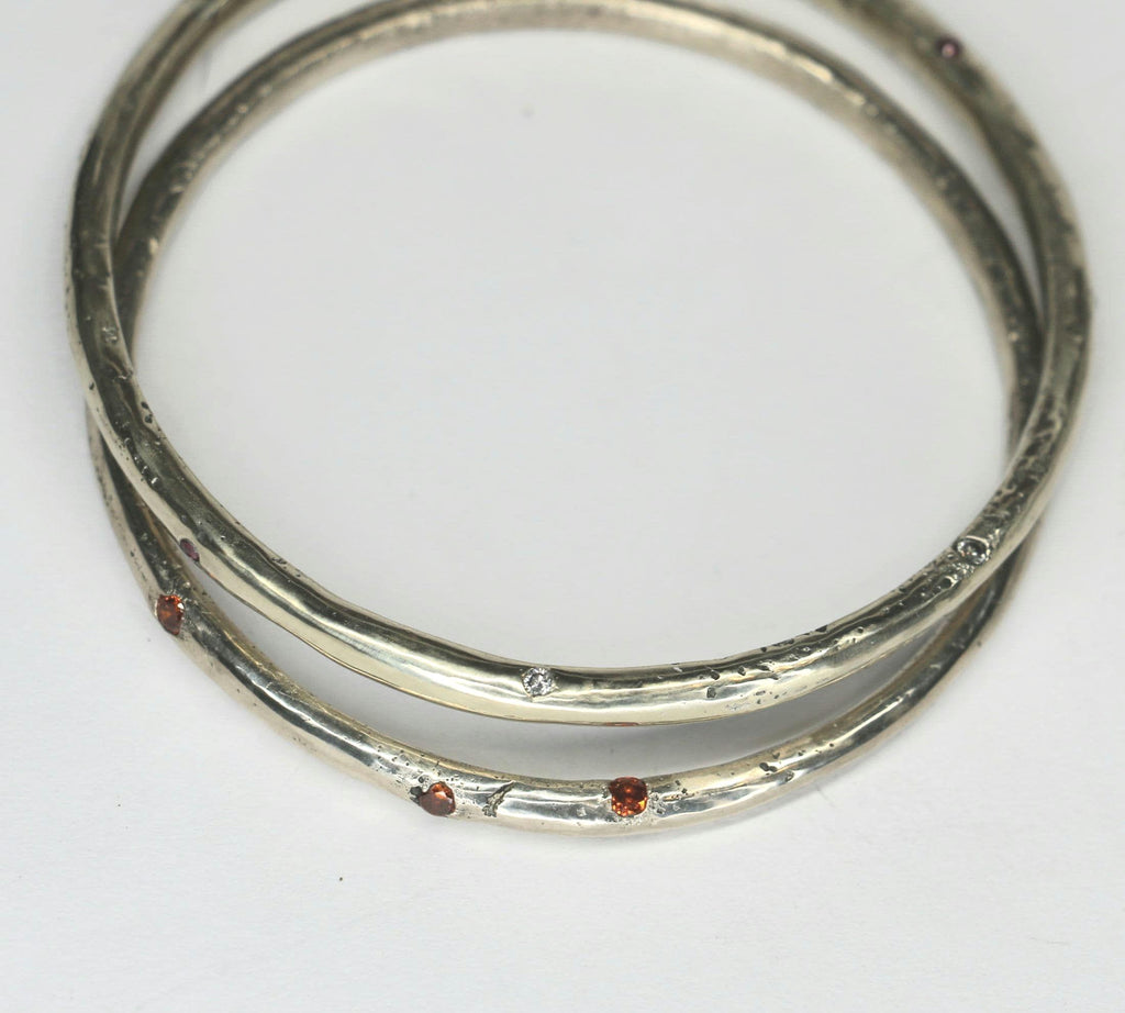 Sandcast bangle textured with gemstones