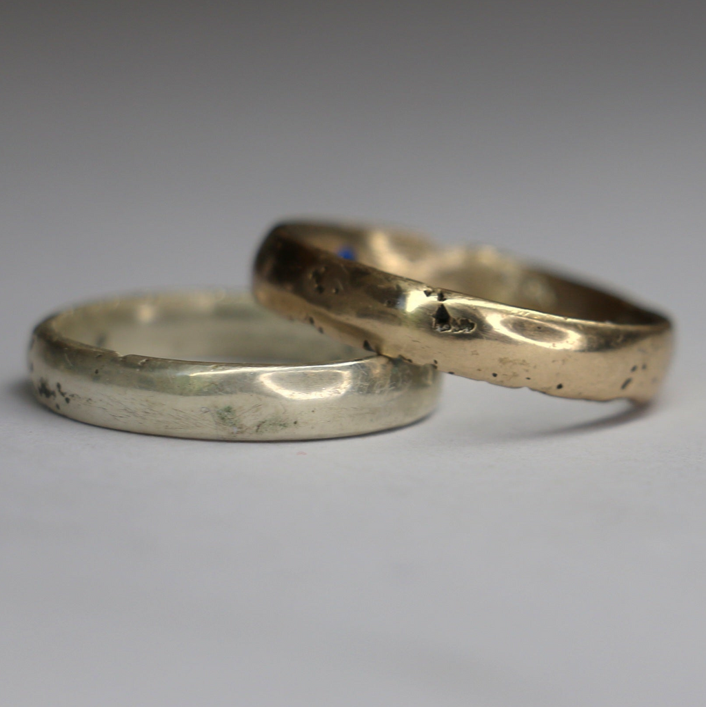 Two gold and silver rings on a gray background